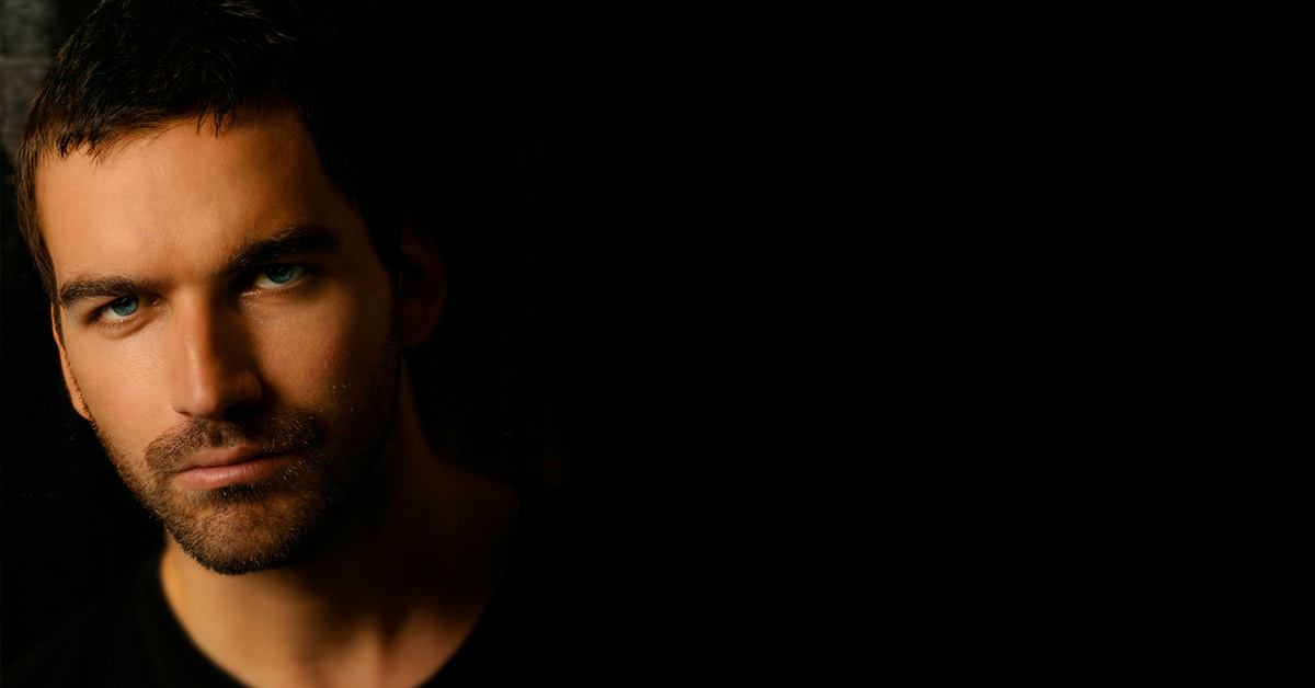 Guy with dark stubbles on black background