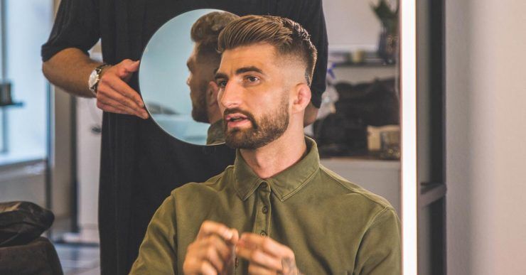 Hairdresser checking undercut with mirror